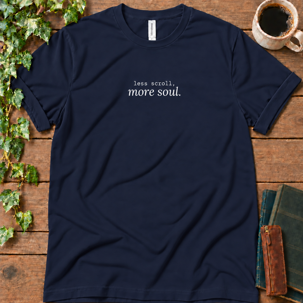 Navy regular-fit tee printed with less scroll, more soul., flat lay on rustic wood with ivy, coffee and vintage books