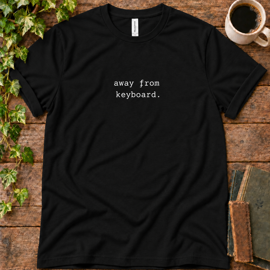 Black regular-fit tee printed with away from keyboard, flat lay on rustic wood with ivy, coffee and vintage books