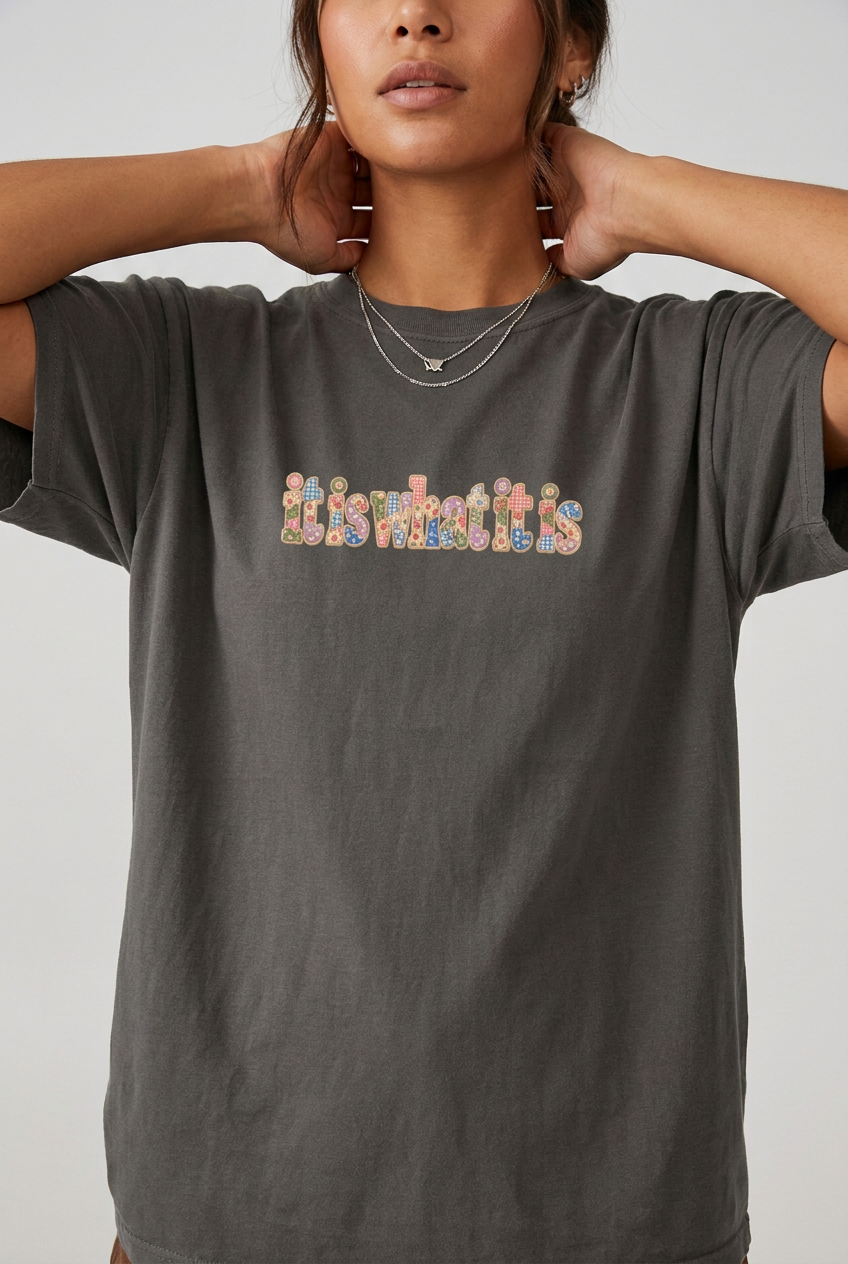Close-up model wearing the it is what it is colourful t-shirt in Pepper