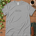 Athletic heather regular-fit tee printed with less scroll, more soul., flat lay on rustic wood with ivy, coffee and vintage books