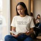 Woman reading wearing Focus on the plot T-shirt in Ivory