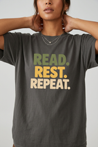 Close-up of woman wearing the Pepper read rest repeat t-shirt with hands behind her neck