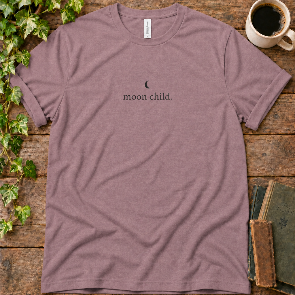 Mauve regular-fit tee printed with moon child, flat lay on rustic wood with ivy, coffee and vintage books