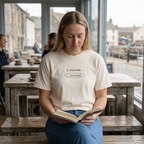 Woman reading in a cafe wearing the Ivory i failed, i learned. t-shirt