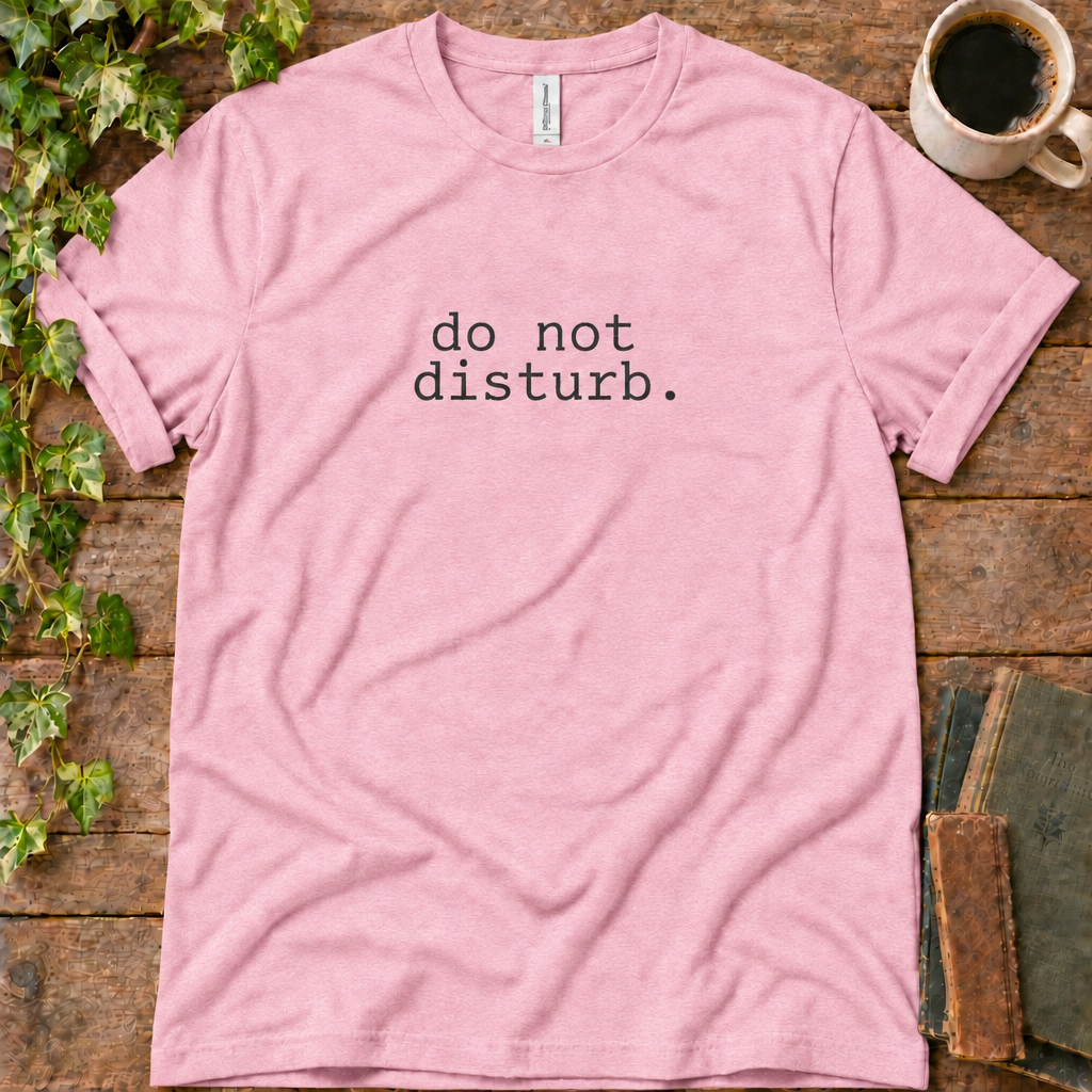 Pink regular-fit tee printed with do not disturb, flat lay on rustic wood with ivy, coffee and vintage books