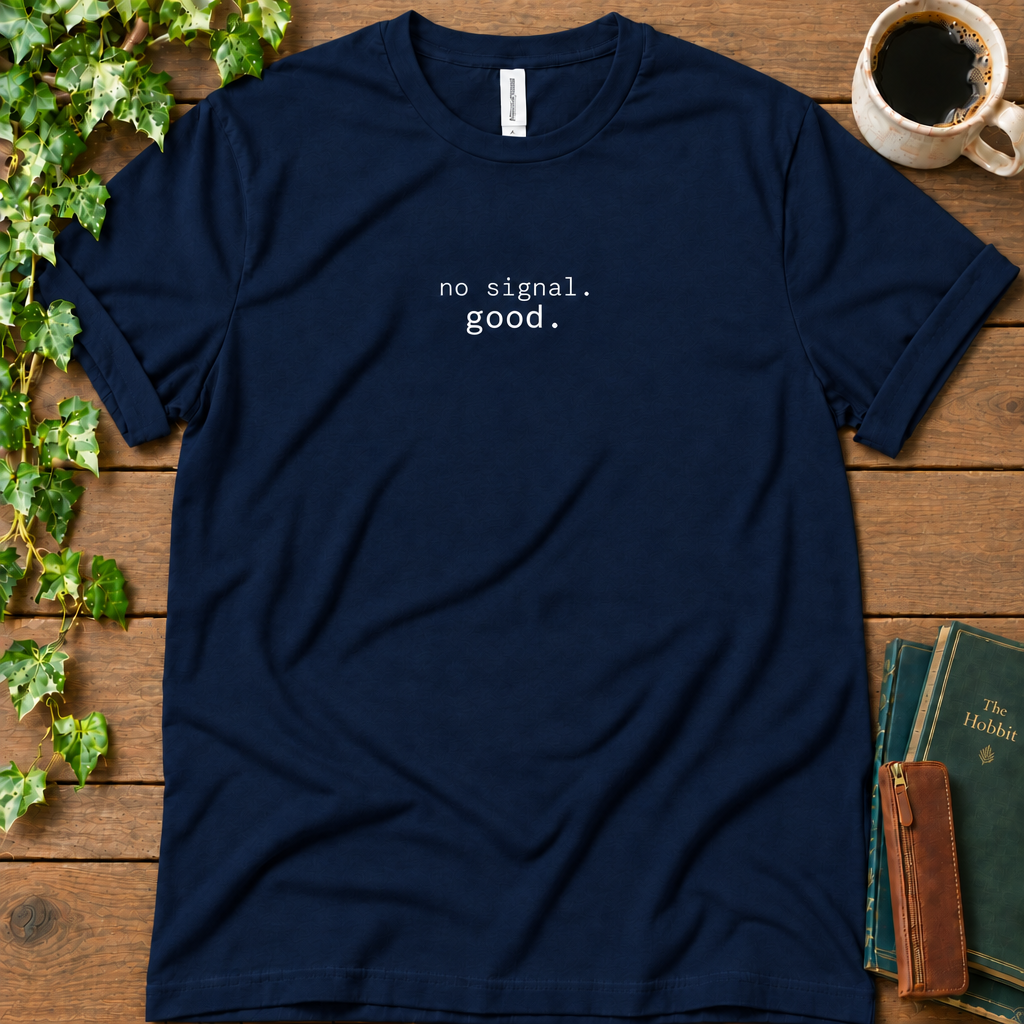 Navy regular-fit tee printed with no signal. good., flat lay on rustic wood with ivy, coffee and vintage books