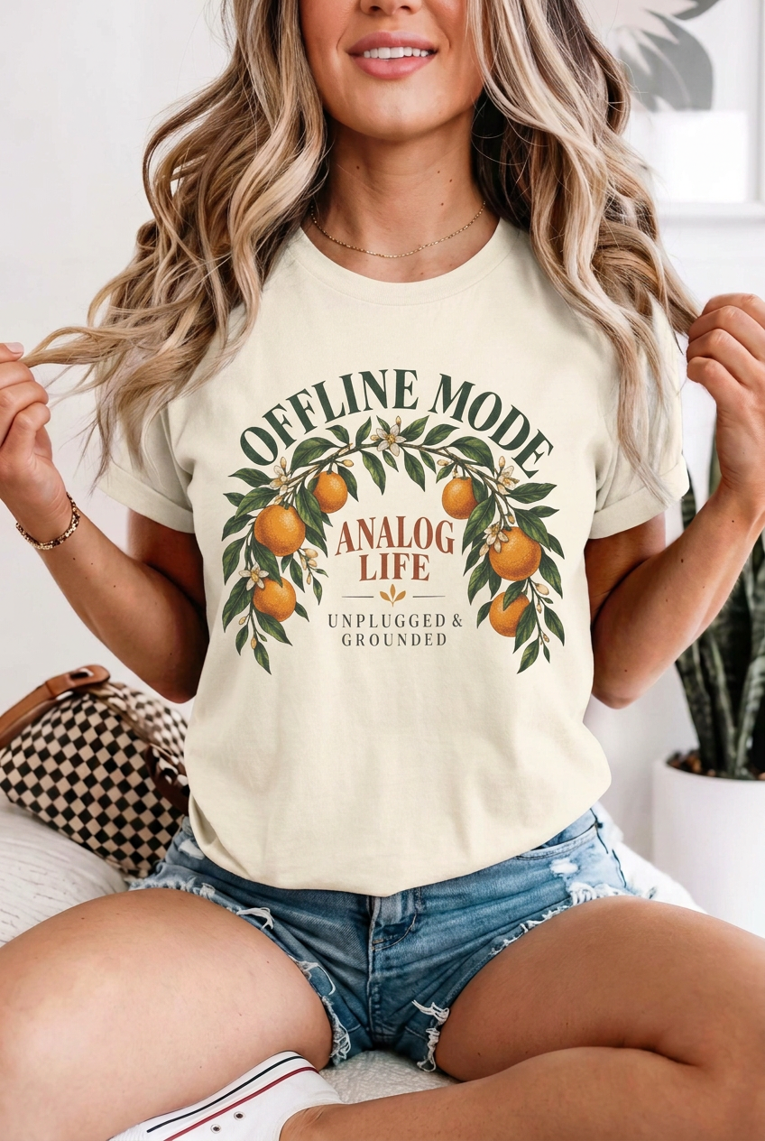 Seated blonde model in denim shorts wearing offline mode analog life t-shirt in Ivory