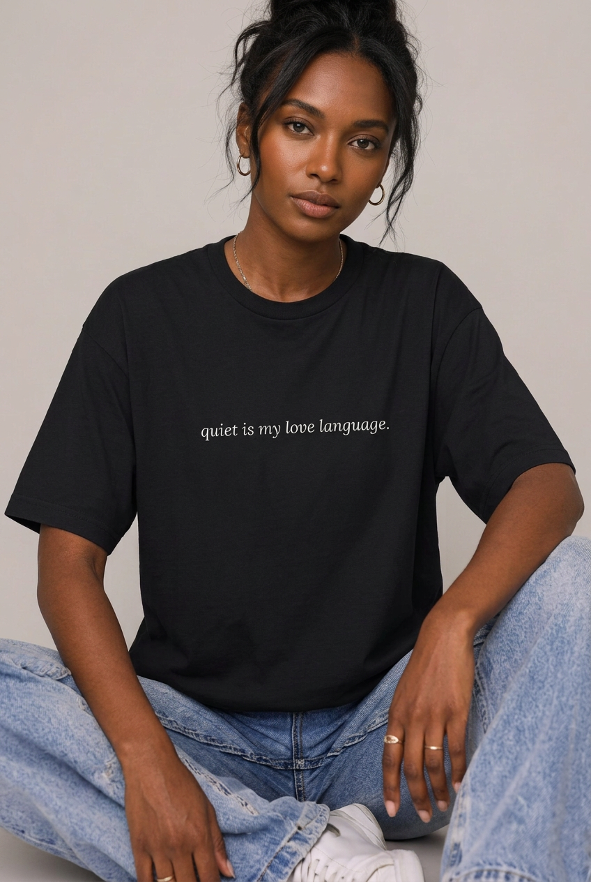 Woman wearing Black quiet is my love language t-shirt, seated editorial lifestyle