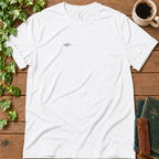 White regular-fit tee printed with ugh. on the left chest, flat lay on rustic wood with ivy, coffee and vintage books
