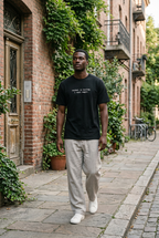 Man wearing the Black normal is boring. i want magic. t-shirt on an urban street
