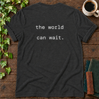 the world can wait. dark grey heather t-shirt back print flat lay
