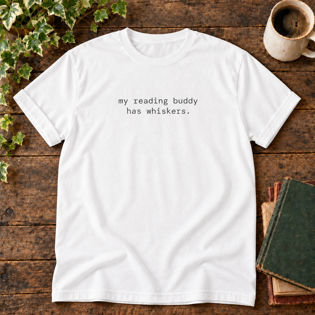 White tee with my reading buddy has whiskers text in rustic flat lay