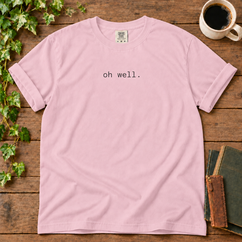 Blossom relaxed-fit tee printed with oh well., flat lay on rustic wood with ivy, coffee and vintage books