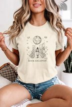 Seated blonde model in denim shorts wearing book escapism reader t-shirt in Ivory