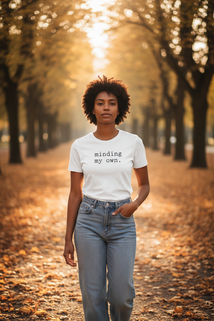 minding my own. — dark-skinned woman, white Bella Canvas, tree-lined path