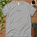 Athletic heather regular-fit tee printed with my person. always., flat lay on rustic wood with ivy, coffee and vintage books