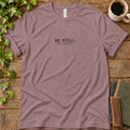Mauve regular-fit tee printed with be still, flat lay on rustic wood with ivy, coffee and vintage books