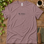 Mauve regular-fit tee printed with be still, flat lay on rustic wood with ivy, coffee and vintage books