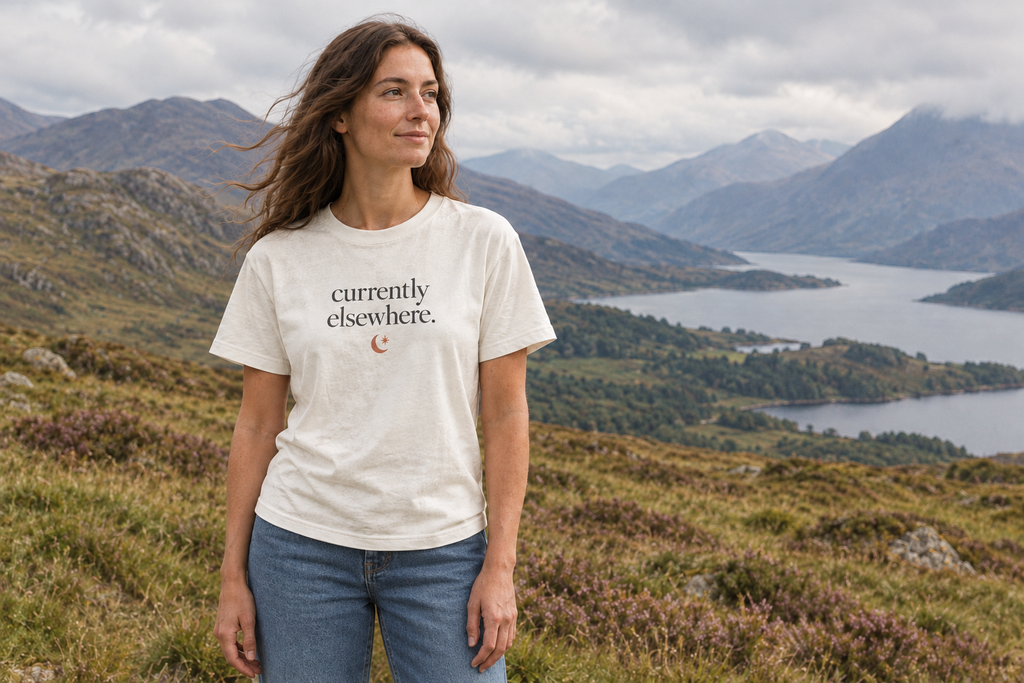 Woman wearing the ivory currently elsewhere. t-shirt and blue jeans in the Scottish Highlands