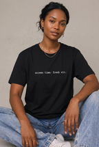 Woman wearing Black screen time fresh air t-shirt, seated editorial lifestyle