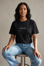 Brown-skinned woman wearing the Black not today. t-shirt, seated studio lifestyle image